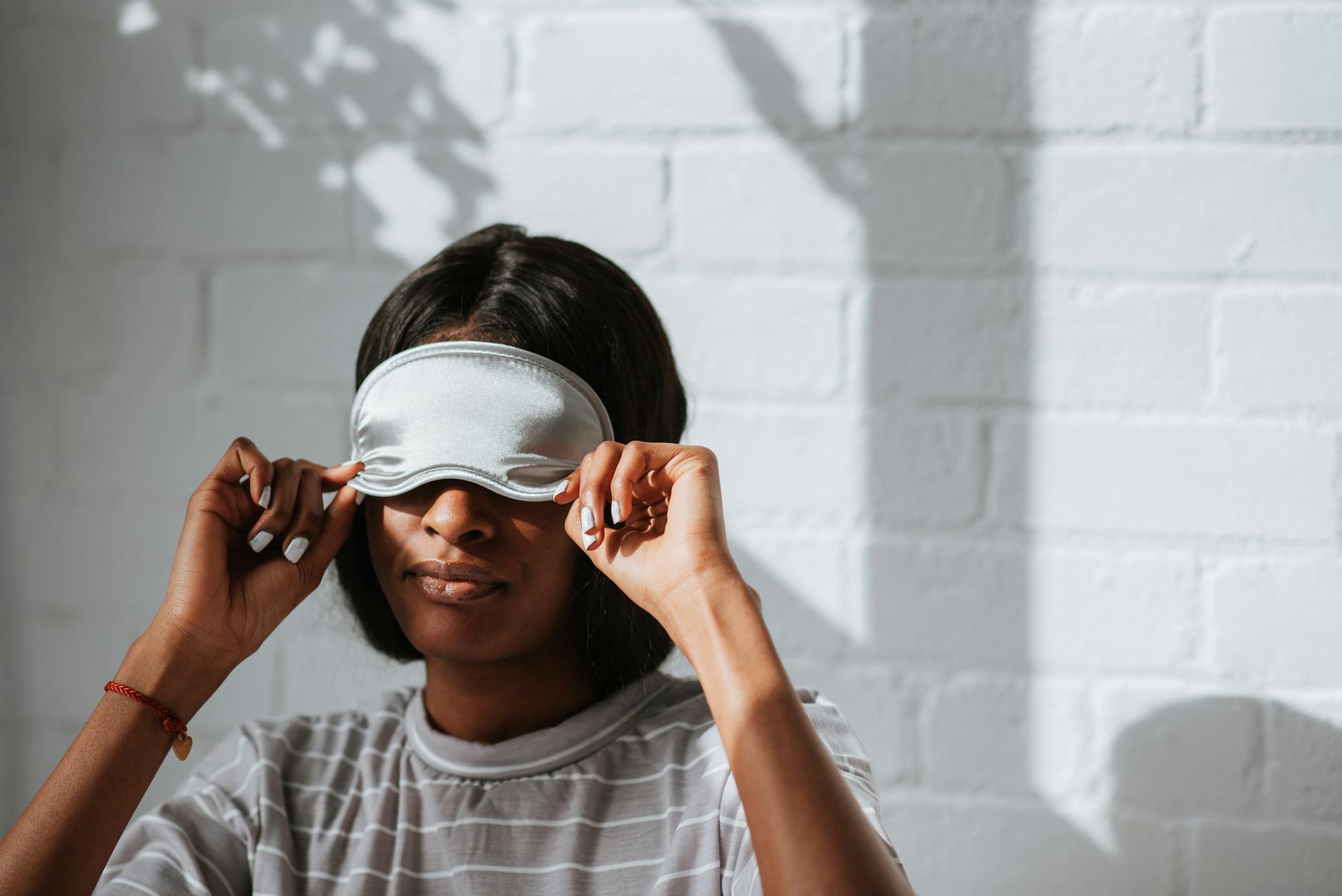 a woman in striped shirt wearing a sleeping mask