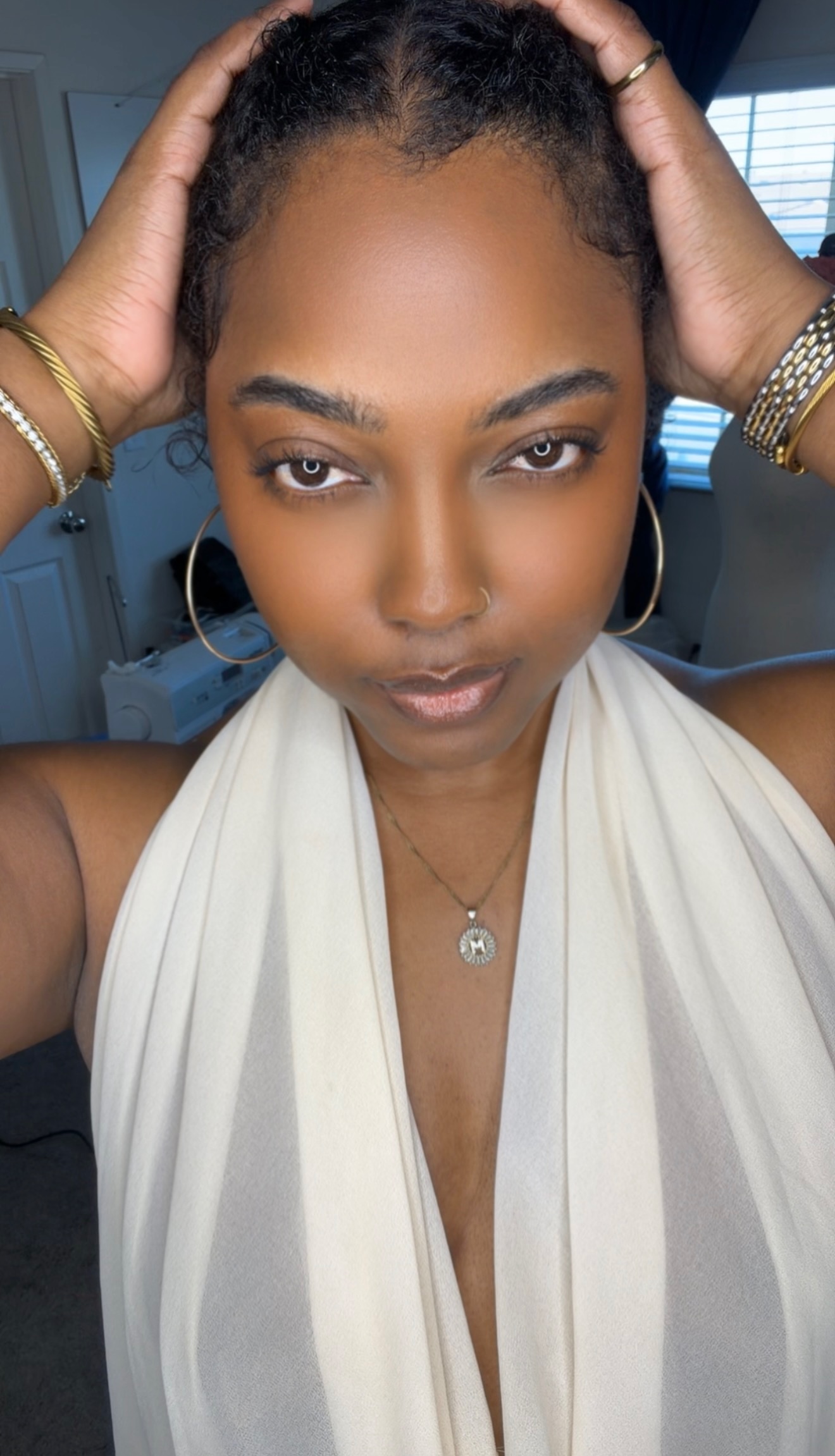 Morgan Ashley in a cream halter top and gold jewelry, natural skin, direct gaze — skin longevity routine at 40